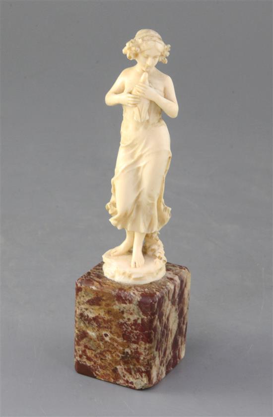 An Art Nouveau French ivory carved figure of a lady with a dove, height 6.5in.